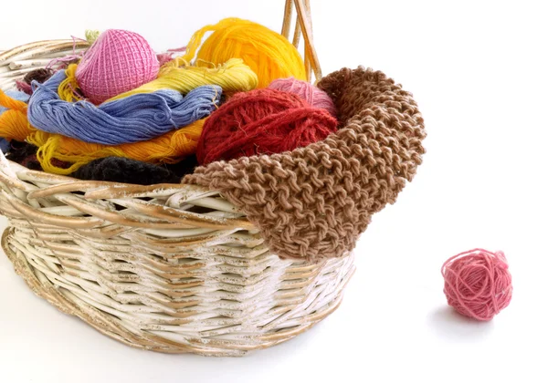 Wicker basket with balls of yarn and knitting needles — Stock Photo, Image